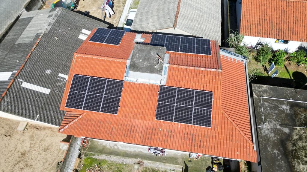 Sistema de energia solar de 6,9 kWp com microinversores em telhado de várias águas na Barra do Aririú, Palhoça/SC